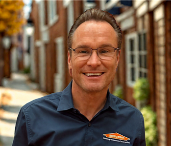 smiling man with brown hair and a blue shirt