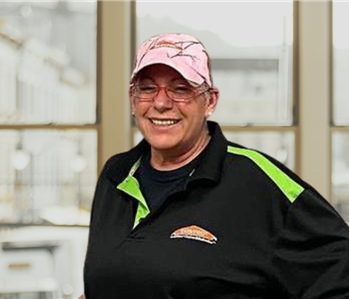 smiling brunette woman with a black Servpro vest on