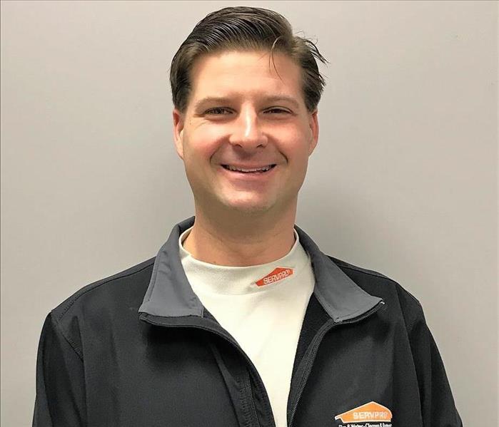 Man with dark hair wearing a jacket with a servpro logo on it