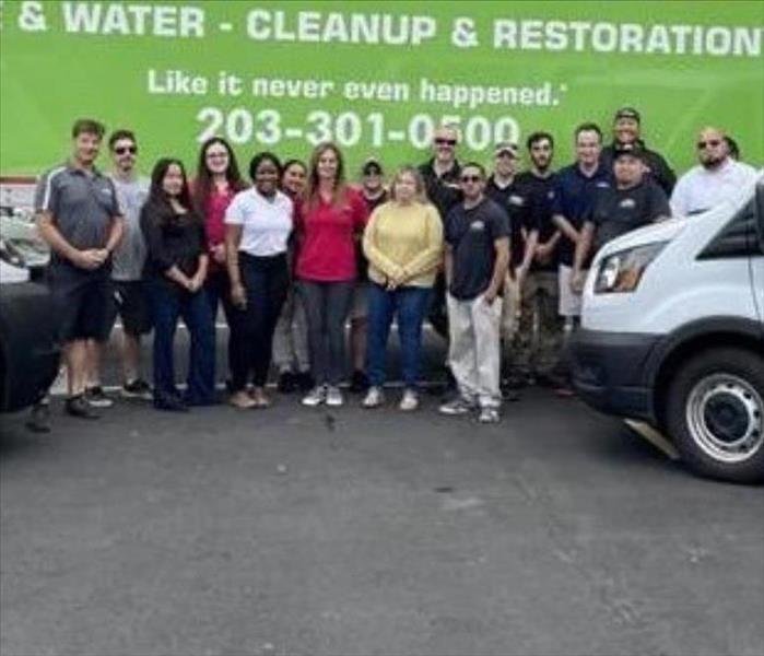 Group of people standing in front of a servpro truck